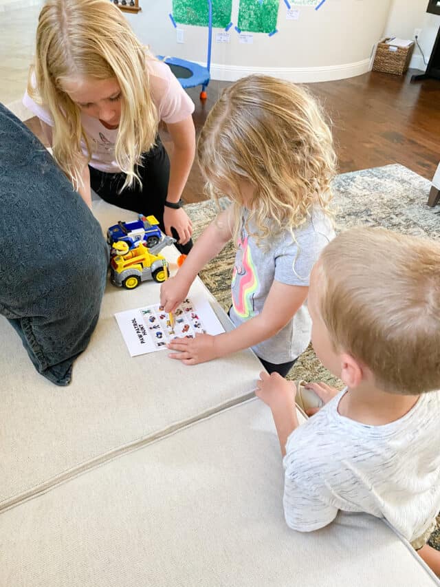 Toy hunt for preschoolers and elementary schoolers two girls and one boy leaning on a couch, writing on a piece of paper