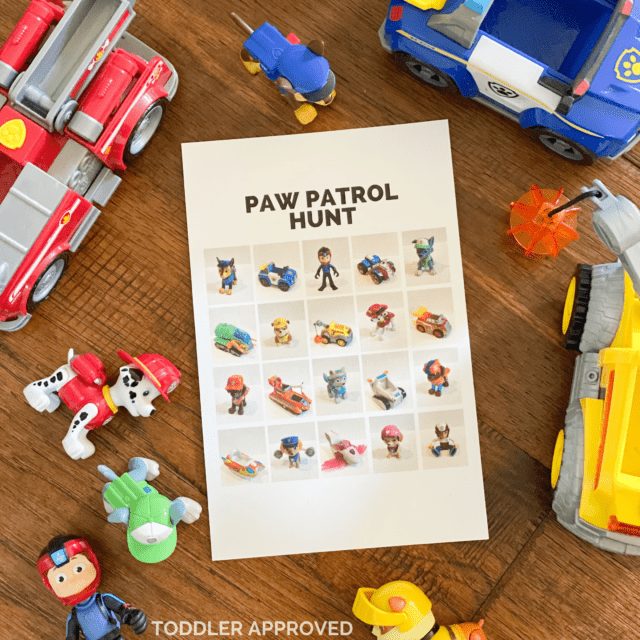 Paw Patrol toy hunt for kids Paw Patrol toys on the floor along with a paper that has Paw Patrol photos on it.